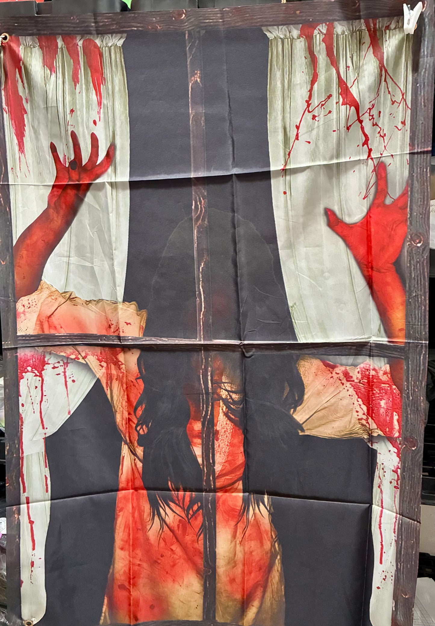 Halloween window curtain featuring a bloody silhouette with long dark hair and red handprints.